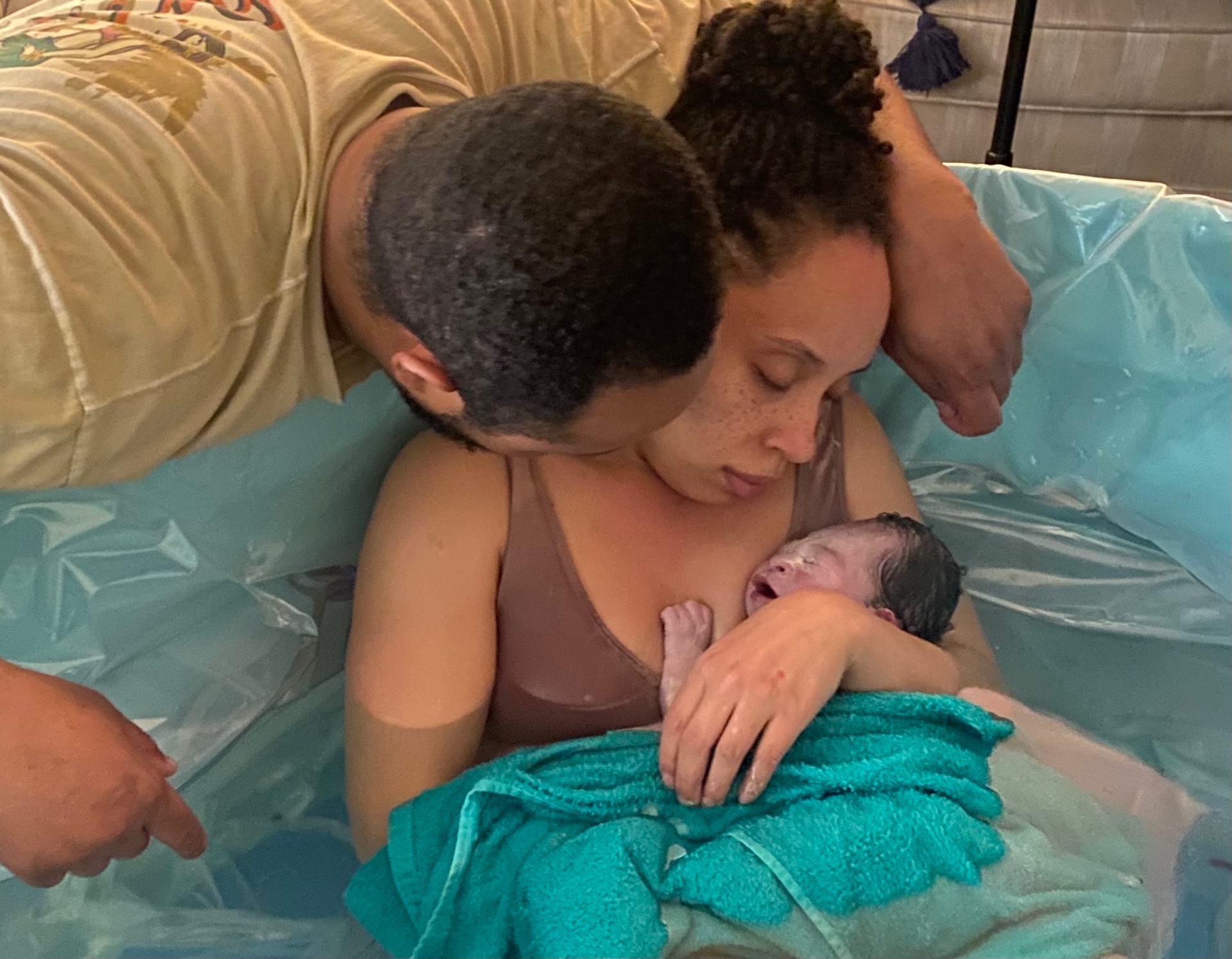 A family welcoming their newborn in a homebirth water pool